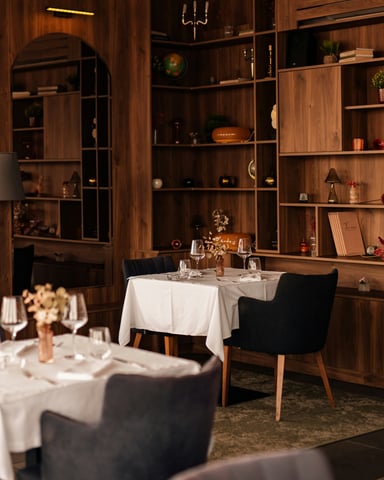 Elegant restaurant interior with walnut shelving, candlelit tables, and wine glasses