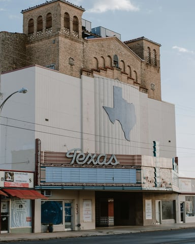 Texas Theater facade with classic brick and neon signage under a blue sky