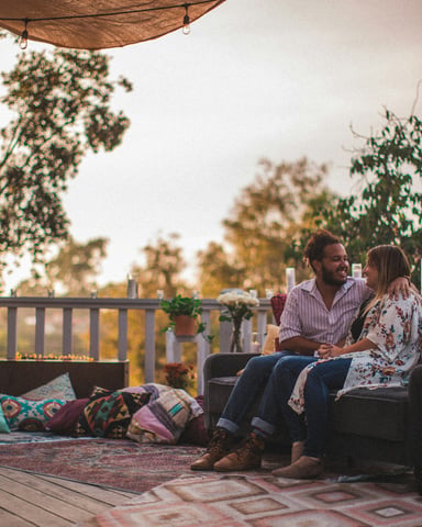 Couple relaxing on a boho porch at golden hour