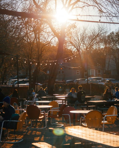 Sunny outdoor patio with string lights and colorful chairs at golden hour