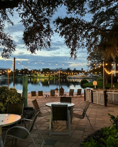 Lakeside patio at dusk with string lights through trees