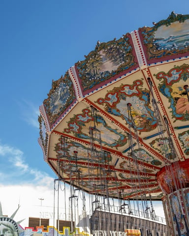 Colorful carnival swing ride spinning against a bright blue sky