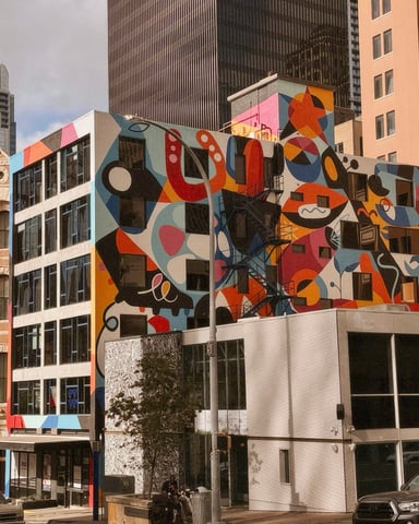 Bold colorful mural covering a downtown Austin building with the skyline behind