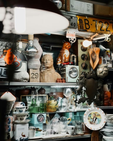 Shelves packed with vintage collectibles, lamps, ceramics, and curiosities