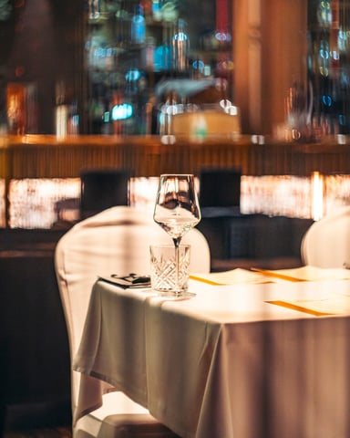 Moody vintage restaurant interior with white tablecloth and warm window light