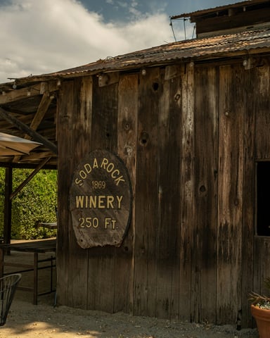 Rustic weathered wood winery building with outdoor patio seating