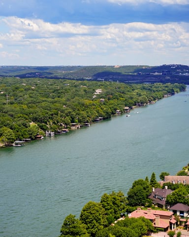 Aerial view of Lake Austin winding through green hills