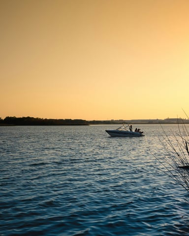Boat on calm lake water at golden-hour sunset
