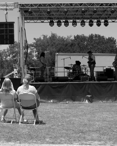 Outdoor festival main stage at Brushy Creek BBQ Festival in Round Rock, Texas under a wide open sky