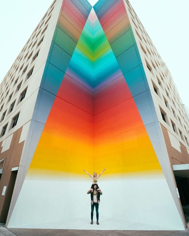 Vibrant rainbow mural on an Austin building with people in front