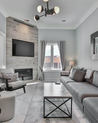 Cozy living room with flat-screen TV mounted above stone fireplace